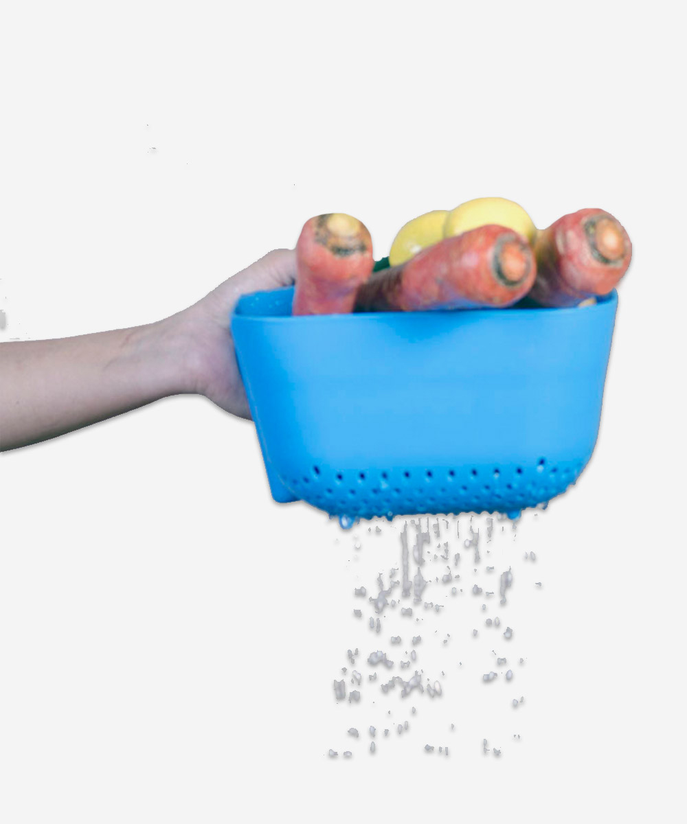 Square colander in use draining fruits and vegetables in the kitchen sink